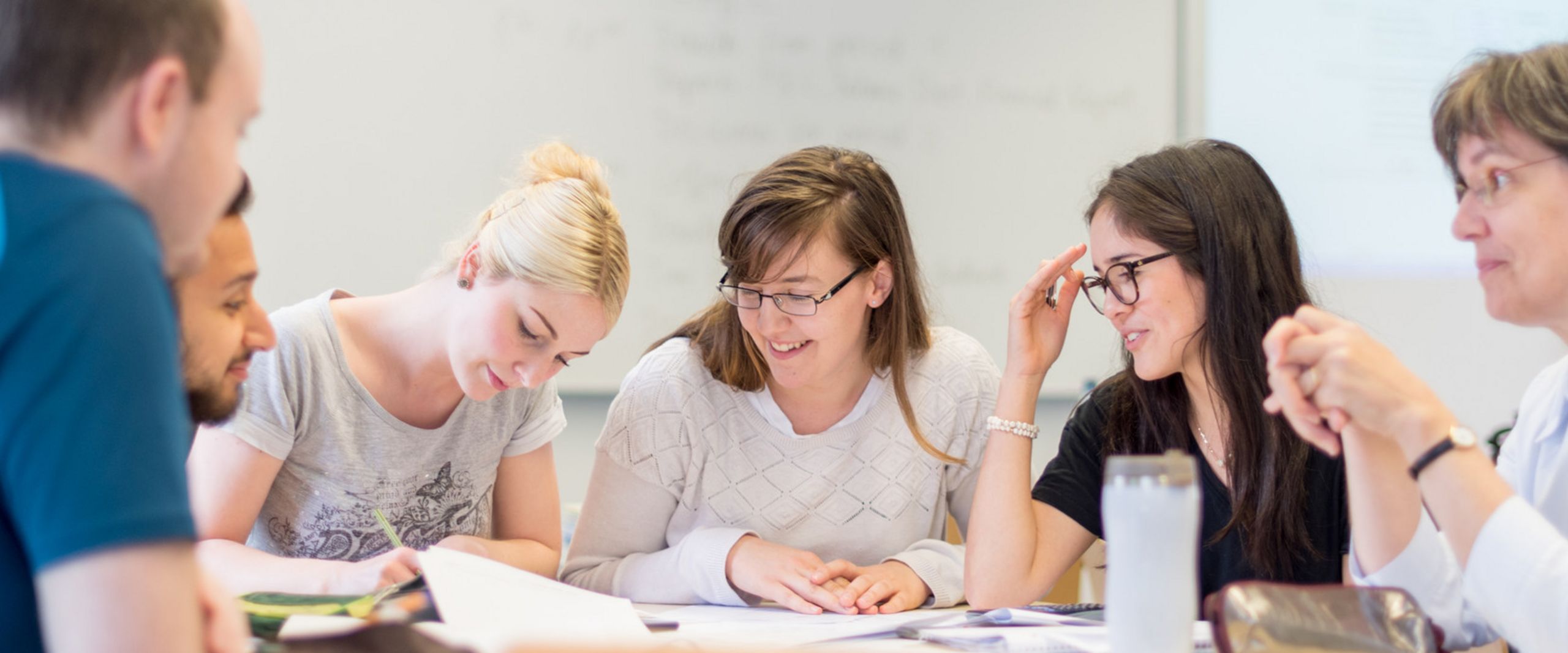 Seminar in den Wirtschaftswissenschaften Prof.Dr. Martina Röhrich sitzt mit einer kleinen Gruppe Studierender an einem Tisch