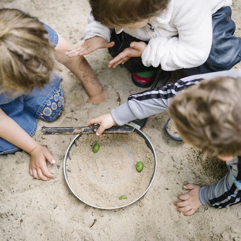 Kinder im Sand Drei Kinder in einem Sandkasten, Ansicht von oben