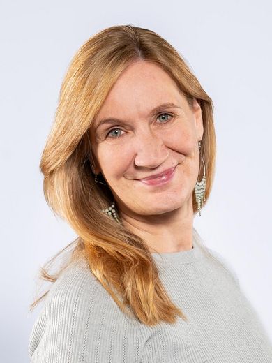 Stefanie Gösling Auf dem Foto ist Stefanie Gösling zusehen. Sie hat lange blonde Haare und trägt einen grauen Pullover.