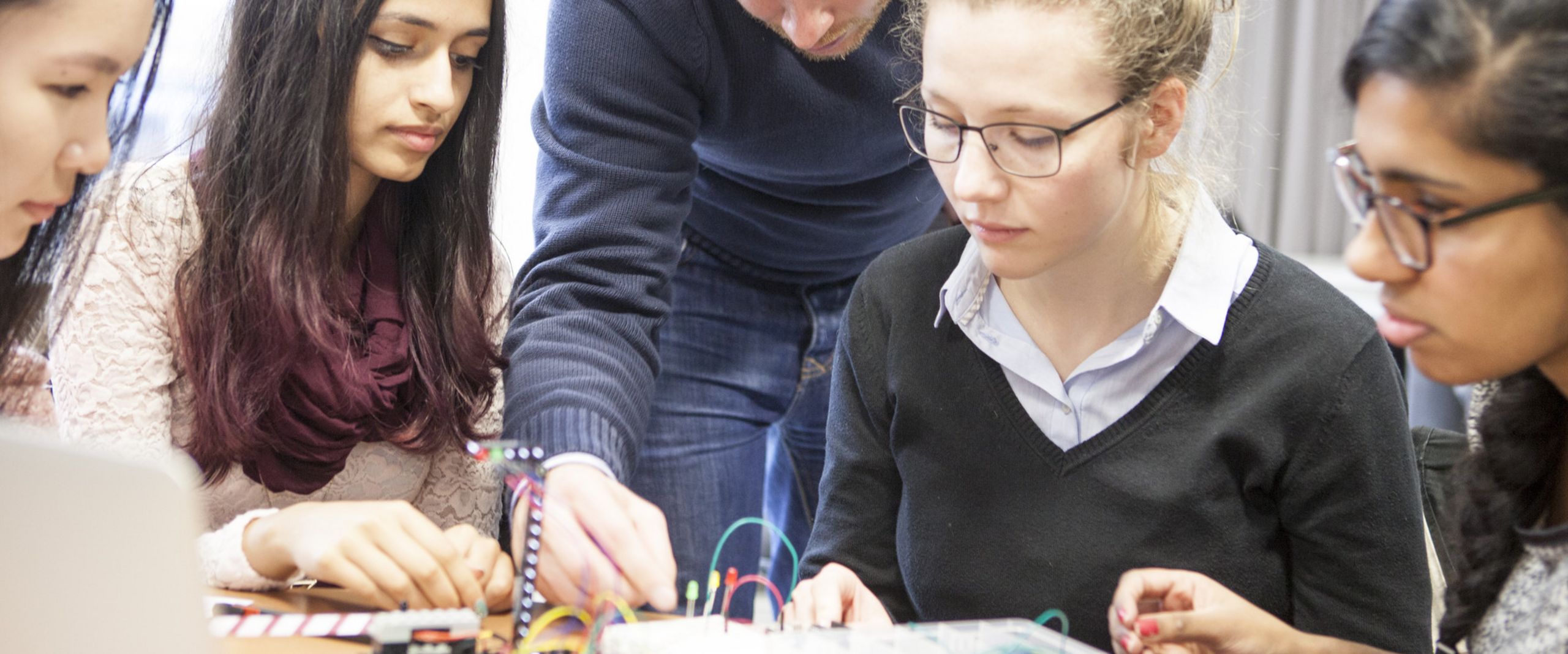 Studentinnen Studierende betrachten Halbleitertechnik.