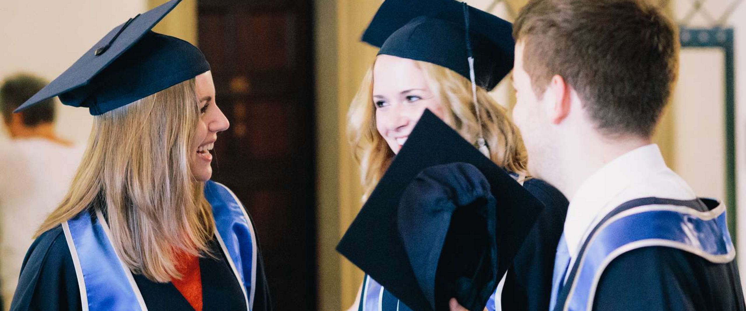 Absolventen 2 Absolventinnen, 1 Absolvent im Talar