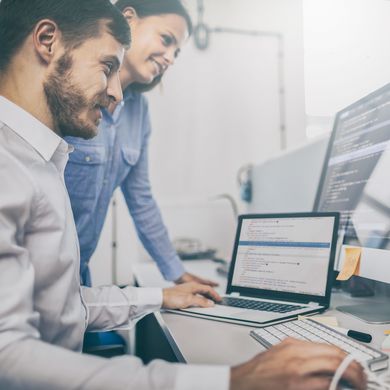 WB Thema Digitalisierung Mann und Frau schauen gemeinsam auf mehrere Computerbildschirme