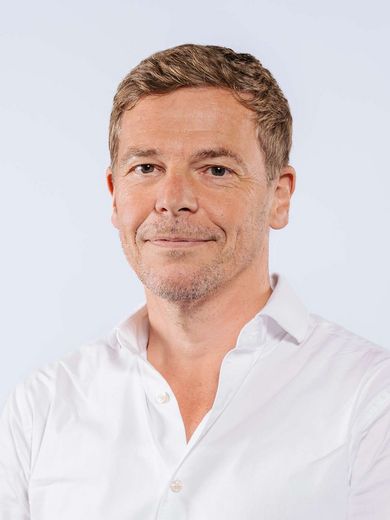 Auf dem Bild ist Andreas Teufel zu sehen. Er hat kurzes braunes Haar und trägt ein weißes T-Shirt. 