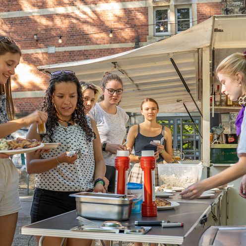 Sommerfest Frauen in MINT 2022 MINT-Studentinnen bedienen sich an einem Buffet am Neusi