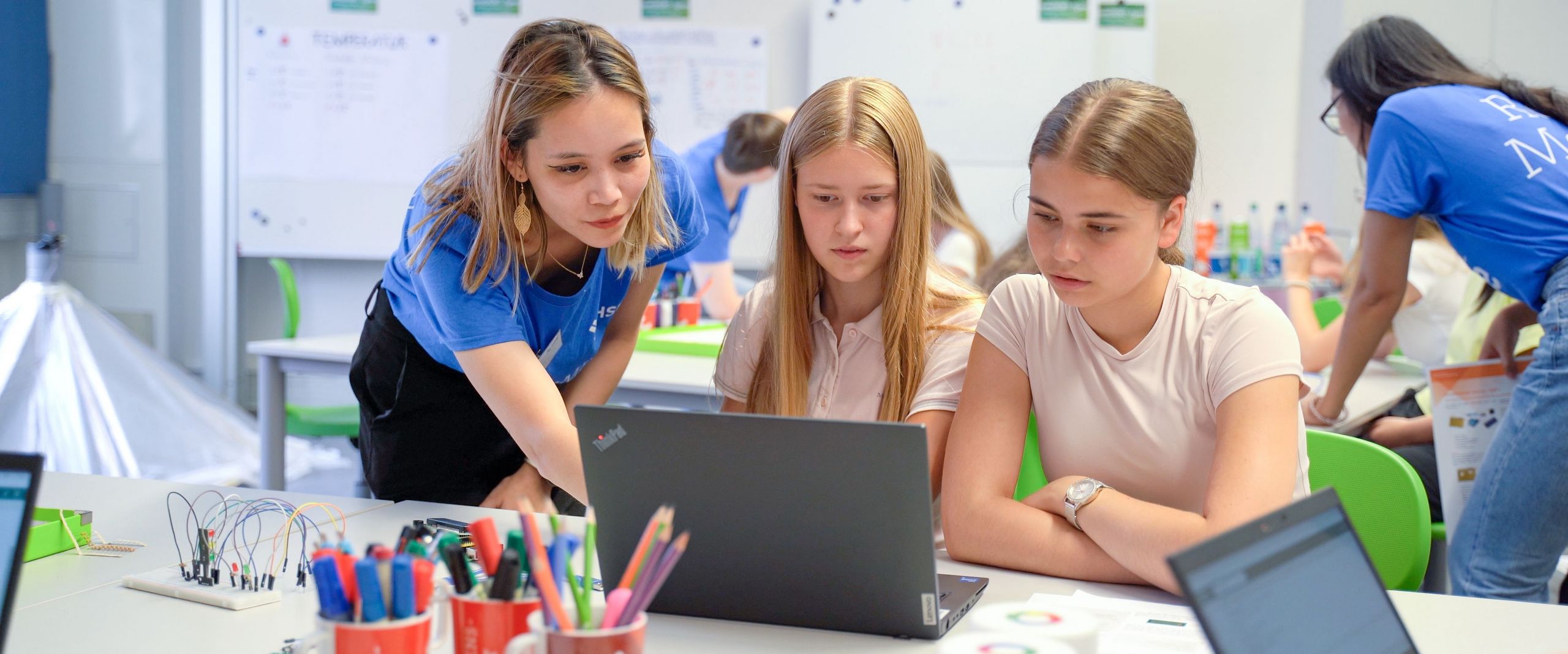 Das studentische Role Model Sophie Mießner unterstütz die Schülerinnen Sylvia Wirth und Luise Büsing beim Programmieren. 