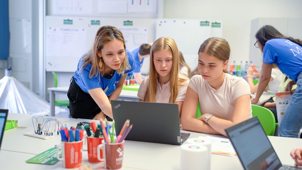 Das studentische Role Model Sophie Mießner unterstütz die Schülerinnen Sylvia Wirth und Luise Büsing beim Programmieren. 