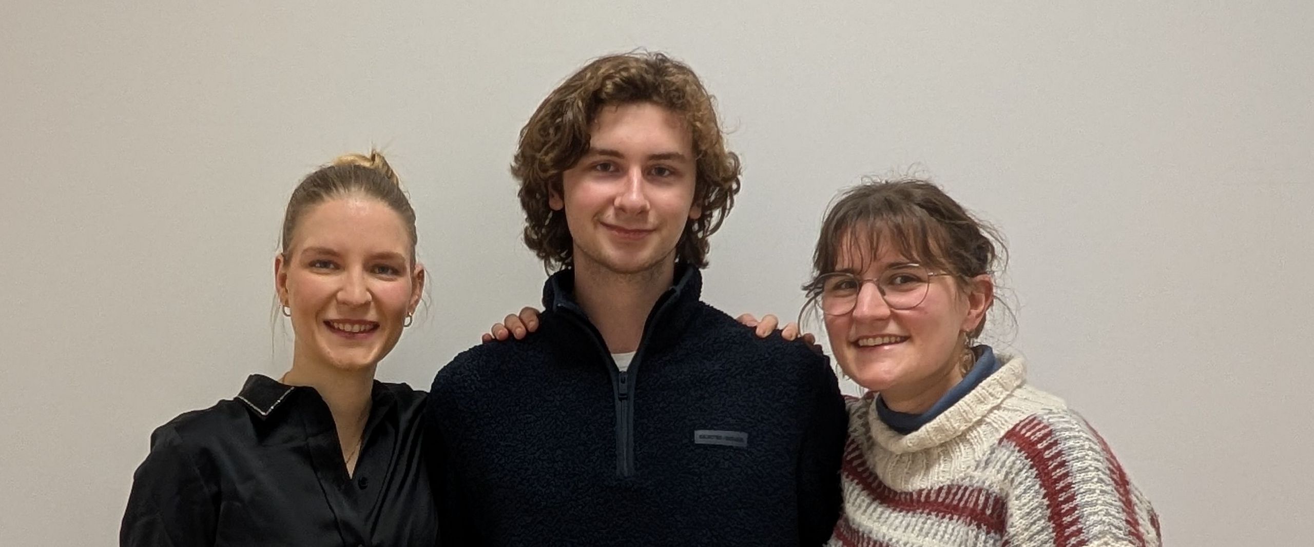 Zwei Studentinnen und ein Student posieren für Gruppenfoto 