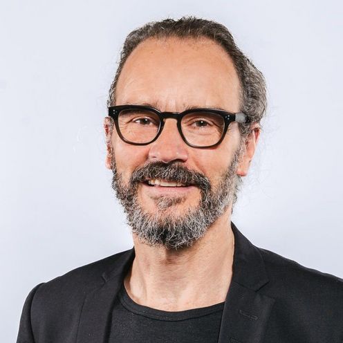 Jörg Müssig Auf dem Bild ist Jörg Müssig zusehen. Er hat schwarz-grau meliertes Haar und Bart und trägt eine schwarze Brille und ein schwarzes T-Shirt unter einem schwarz Jackett.