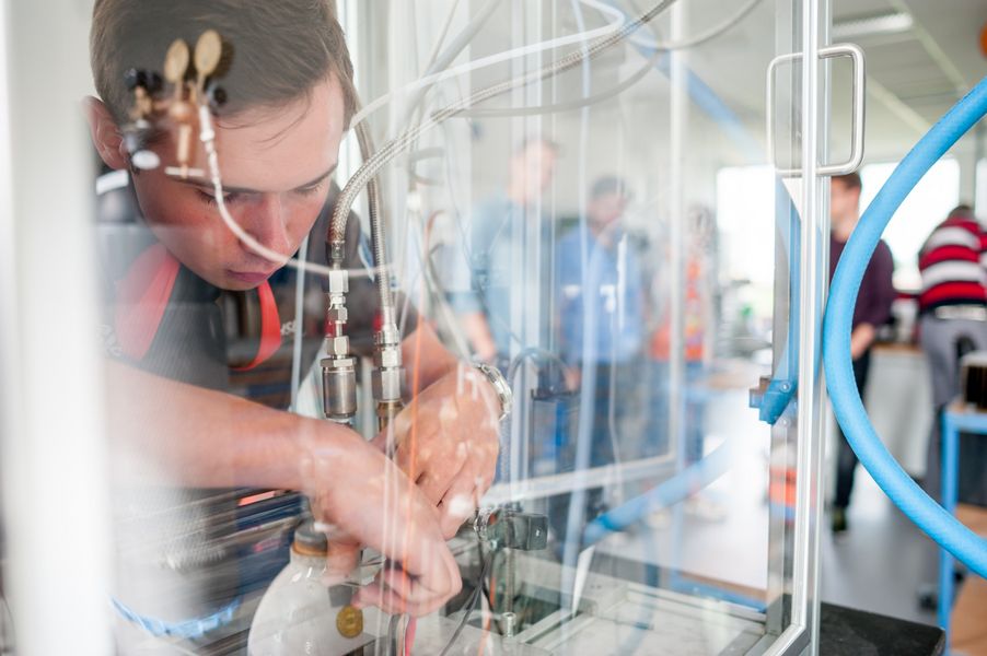 Laborversuch Hybridraketentriebwerk Ein Labormitarbeiter arbeitet am Versuchsaufbau eines Raketentriebwerks.