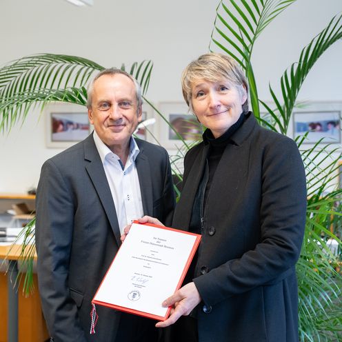 Ernennung Bremer Rektor Prof. Dr. Konrad Wolf und Prof. Dr. Stefanie Bremer. schauen in die Kamera. Frau Bremer hält ihrer Ernennungsurkunde