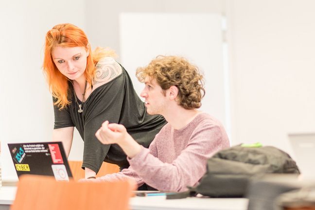 Studierende Zwei Studierende betrachten einen Laptop.