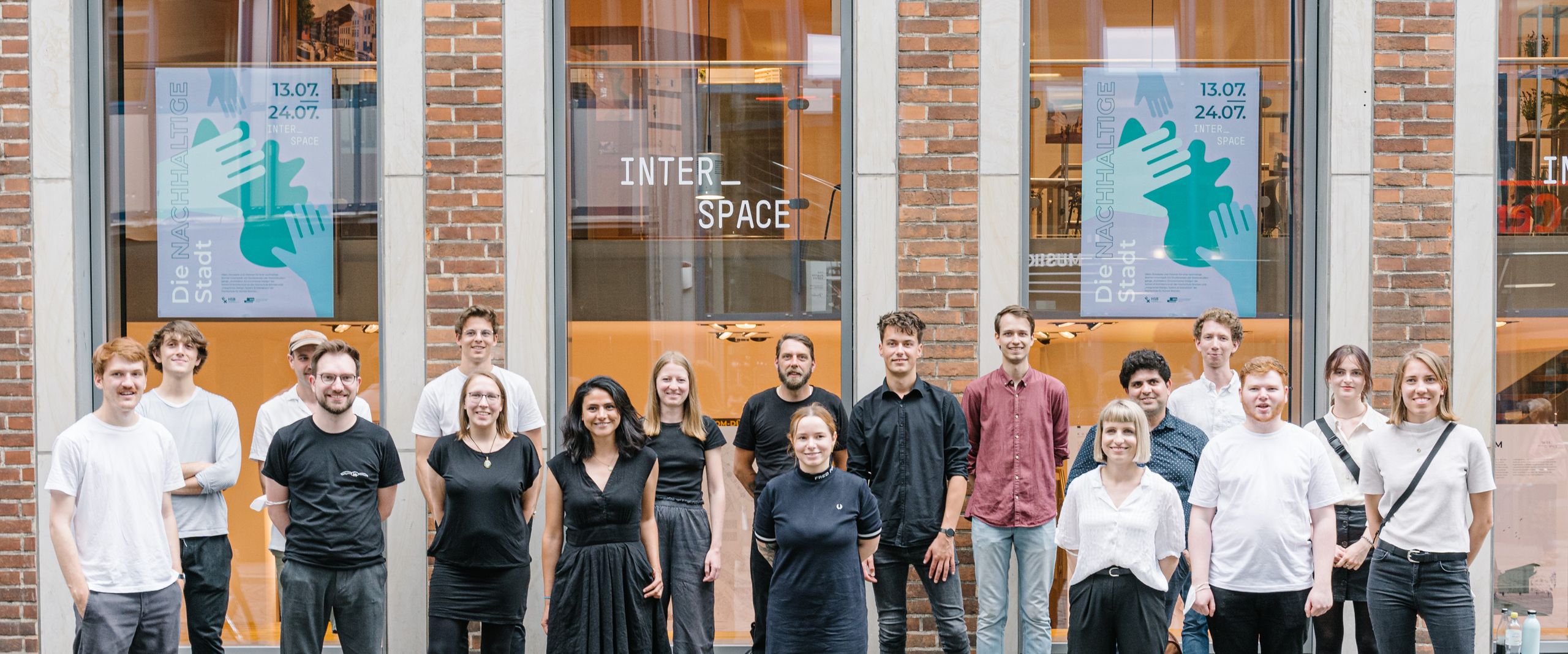 Interspace Studierende vor ihrer Ausstellung 2021 Gruppe Studierender stehen mit Abstand vor Gebäude