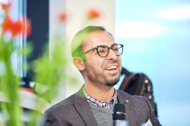 Person männlich Männliche Person an Mikro, schaut lächelnd nach oben