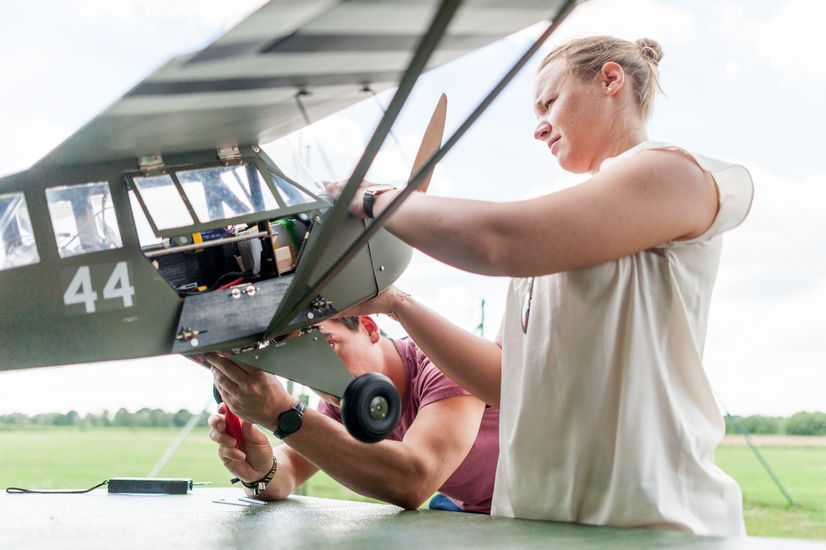Modellflugzeug Zwei Studierende schrauben an einem Modellflugzeug.
