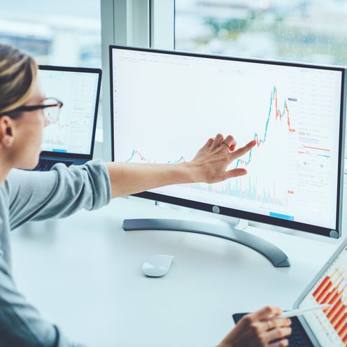 Di_Data_Engineering_Angewandte_Datenanalyse Frau vor einem Computerbildschirm zeigt auf Statistik