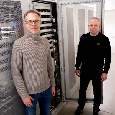 RZ Teschke, Braubach Zwei Männer stehen vor einem Server. Der Hintergrund ist hell und weiß.