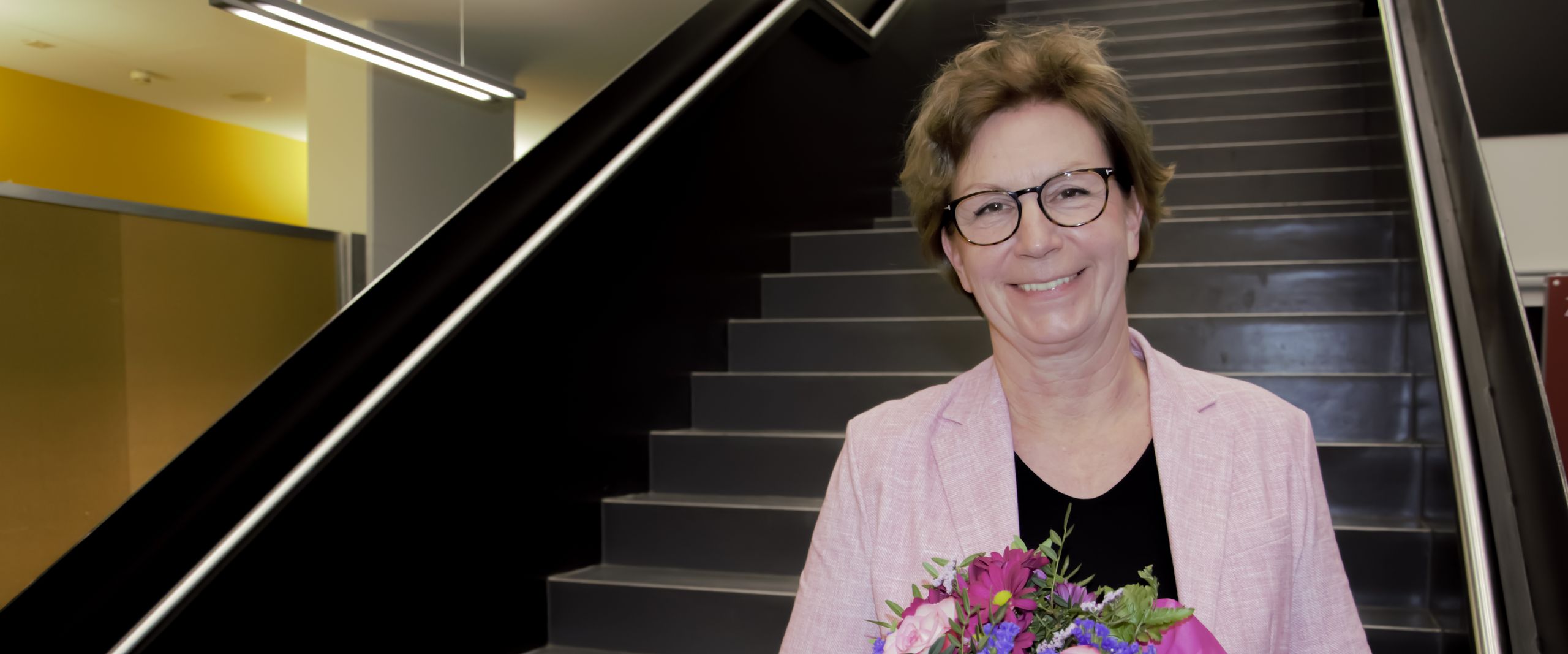 Bestellung Konrektorin Silke Eckardt Woman with bouquet of flowers stands on stairs and laughs into the camera