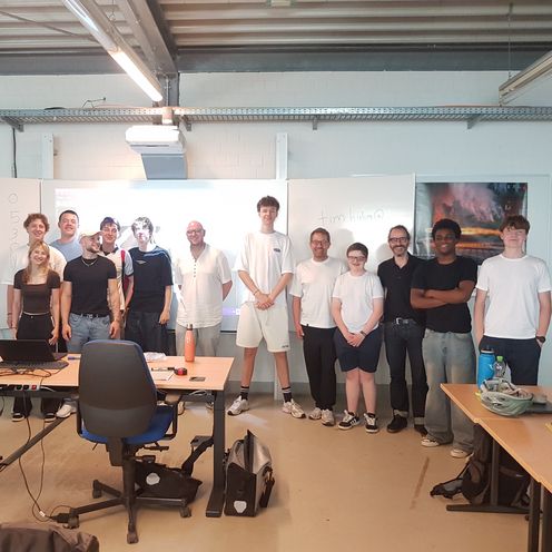 Schülerinnen und Schüler im TrashForm-Workshop Schülerinnen und Schüler posieren zu Gruppenfoto vor Tafel