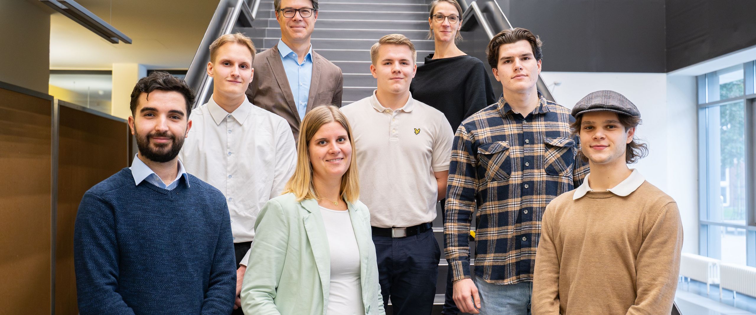 Gruppenfoto: Studierende und Lehrende auf Treppe 