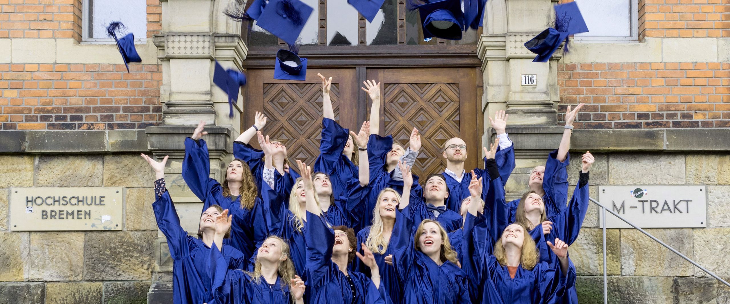 Hütewerfen Absolvent:innen des Studiengangs Angewandte Therapiewissenschaften werfen Ihre Doktorhüte in die Luft.