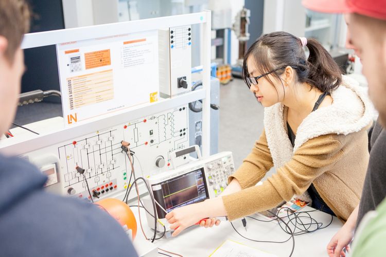 RS4364__MG_821220151123-lpr.jpg Veranstaltung des Studiengangs Elektrotechnik. Eine Studentin hantiert mit Kabeln an einem Gerät.
