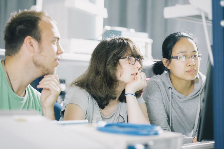 Studierende im Labor Studierende in einem Labor blicken auf einen Monitor.