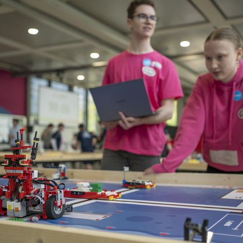 WRO 2025 an der HSB Zwei Personen steuern einen Roboter aus Klemmbausteinen