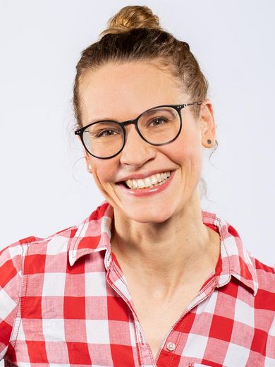 Ulrike Jacobs Auf dem Bild ist Ulrike Jacobs zusehen. Sie hat ihre blonden Haare zu einem Dutt zusammengesteckt. Sie trägt eine Brille und eine rot-weiß karierte Bluse.