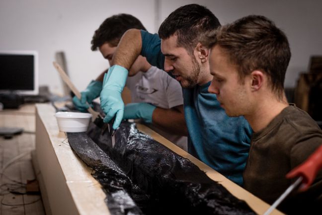 Werkstatt Waterbike-Team Drei Studierende arbeiten an einem Boot.