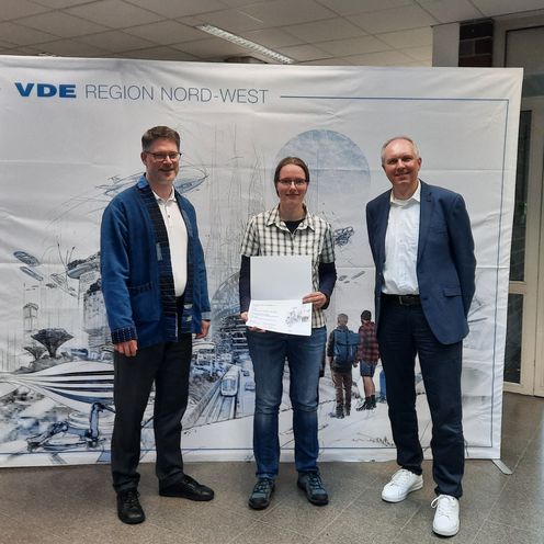 VDE Preis 2026 gruppenbild mit einer Frau und zwei Münnern. Die frau hält eine Urlunde in die Kamera